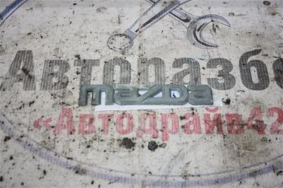 Лот: 21718372. Фото: 1. эмблема Mazda Demio DW3W. Двигатель и элементы двигателя
